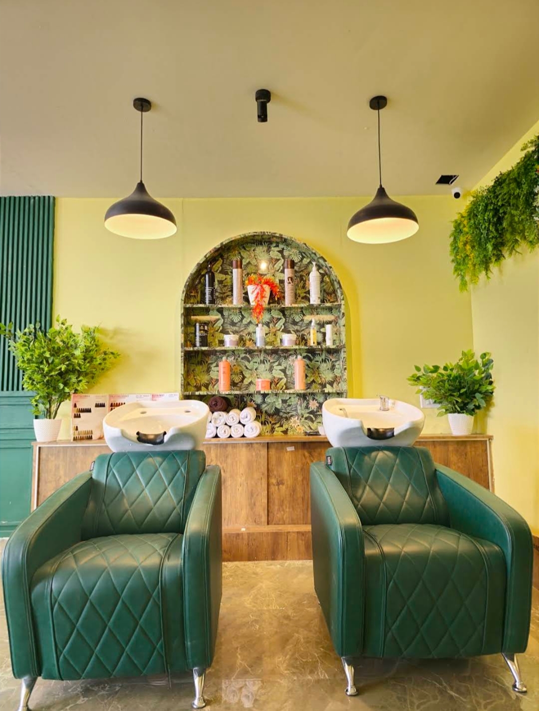 Green wash chairs in front of a shelf of hair products